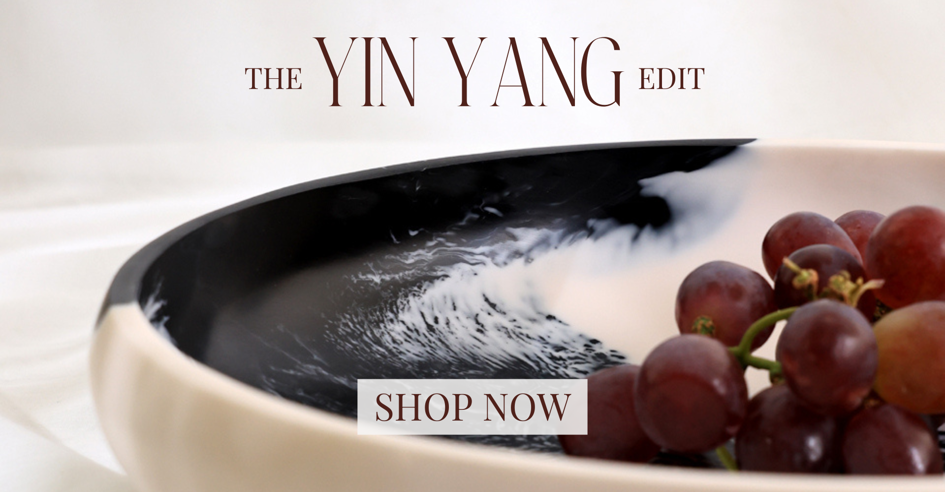 Marble-patterned dish with grapes and 'The Yin Yang Edit' branding.